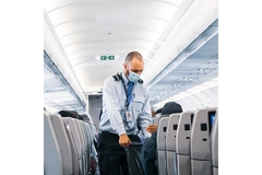 Image Flight attendant collects waste from passengers.